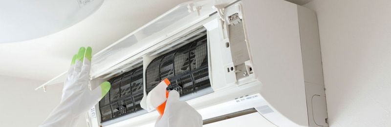 HVAC technician repairing an air conditioner unit in San Diego CA